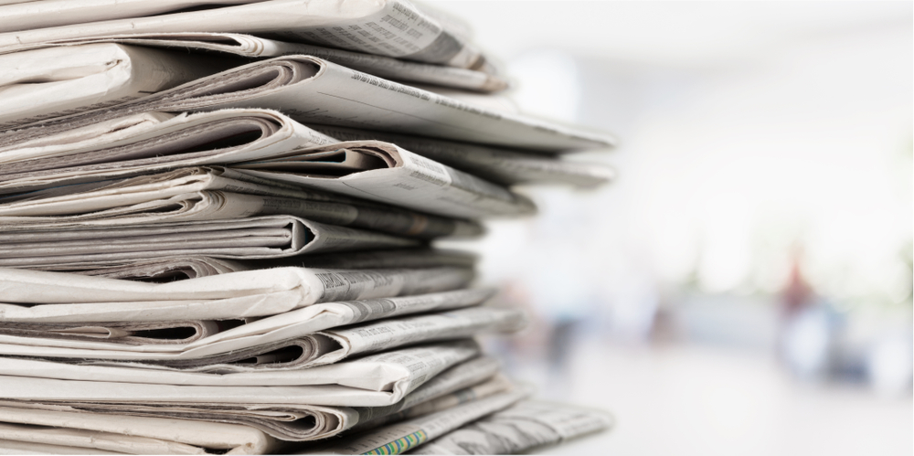 Pile,of,newspapers,on,white,background
